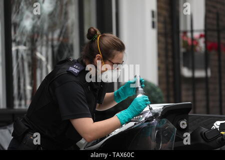 Controllo di polizia un ciclomotore al di fuori delle ore di casa sulla Duke Street, Westminster, dove ciclomotore-riding rapinatori di mira la luxury watch shop, rendendo con gli oggetti rubati dal fracassato vetrina. Foto Stock