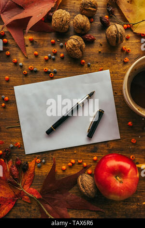 Autunno busta posta flat lay mock up sul tavolo in legno decorato a secco con foglie di acero e frutta di stagione Foto Stock