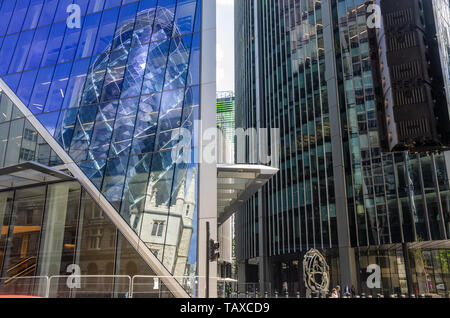 Il Gherkin è visto in una riflessione int egli lato del bisturi nel quartiere finanziario della City di Londra, Regno Unito Foto Stock