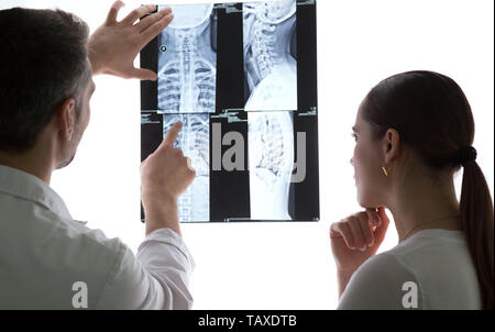 Due medici a discutere di pazienti x-ray e scansioni MRI, colonna vertebrale raggi x Foto Stock