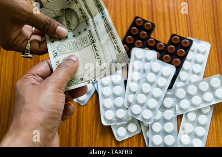 Il cliente offre del denaro per comprare il farmaco alla farmacia farmacia. Vista ravvicinata. Varie capsule, compresse, pillole in medicina shop su sfondo tabella. Pharmac Foto Stock