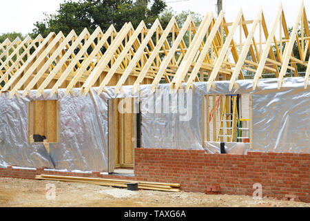 Casa con struttura in legno interno o allegato in costruzione con lamina di moderno e di isolamento esterno muro di mattoni Foto Stock