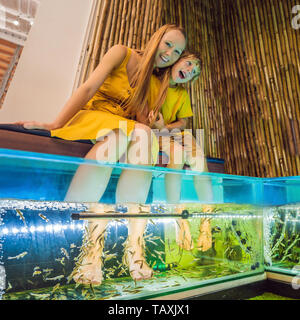 Madre e figlio presso il centro termale di pesce Foto Stock