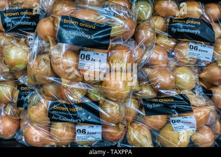 Sacchetti di plastica di Nuova Zelanda rosolare le cipolle per la vendita in un Sainsbury's supermercato. Foto Stock