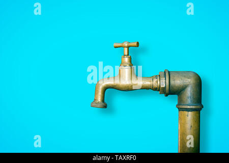 Dettaglio di una acqua di rubinetto in ottone isolato sul colore di sfondo a tinta unita - immagine con spazio di copia Foto Stock
