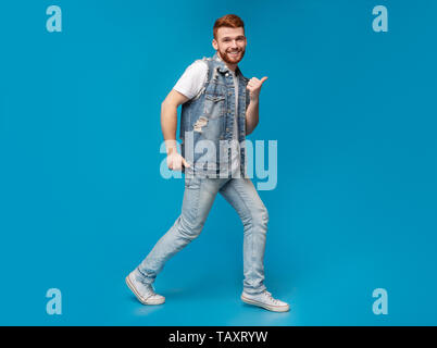 Raffreddare la millenaria uomo ballando con pollice in alto i gesti in studio Foto Stock