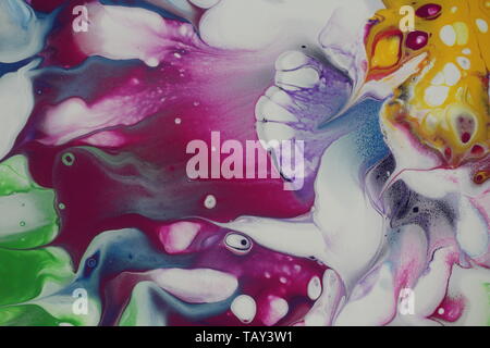 Primo piano di un fantastico acrilico astratto versare la pittura che è fatto a magenta, viola, blu reale, calce verde e bianco. Foto Stock