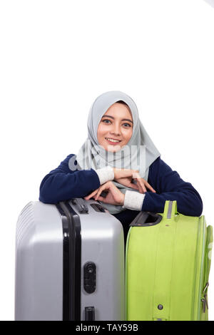 Sorridente donna asiatica con suitccase guardando la telecamera isolate su sfondo bianco Foto Stock