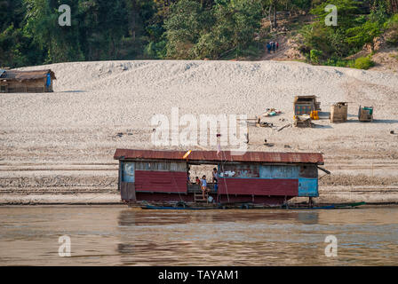 Il fiume Mekong, Laos - Feb 2016: famiglia laotiano vive in una casa galleggiante sul fiume Mekong Foto Stock