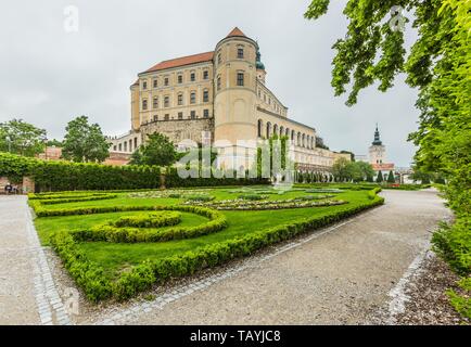 Mikulov, Repubblica Ceca / Moravia del Sud - 28 Maggio 2019: Mikulov castle di colore giallo e con facciata bianca in piedi su una roccia e prato verde in un giardino. Foto Stock