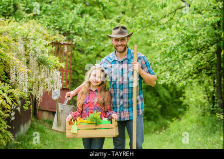 Padre e figlia sul ranch. azienda di famiglia. ecologia. Utensili da giardinaggio. bambina e uomo felice papà. La giornata della terra. molla village country. Facendo un bel mazzo di fiori. Foto Stock