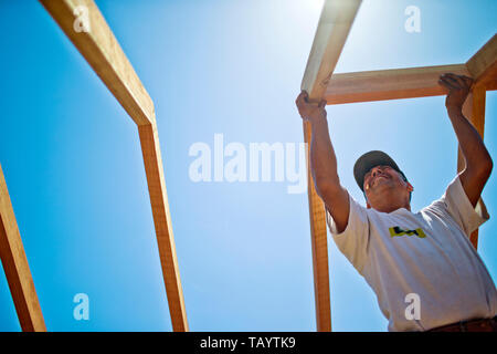 Builder il taglio di un pezzo di legno con una sega circolare. Foto Stock