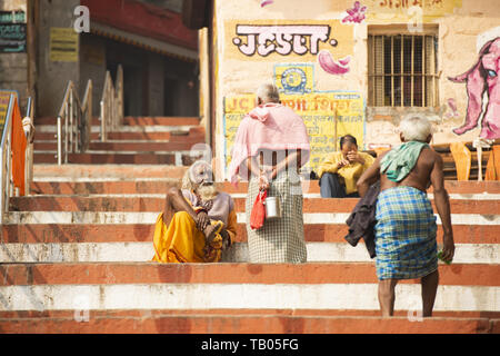 Alcuni Sadhus e persone indù sono rilassanti e camminare sui Ghat di Varanasi. Sadhu è un asceta o qualcuno che pratica yoga. Foto Stock