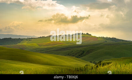 Dolci colline della Toscana in una giornata di sole con nuvole drammatico Foto Stock