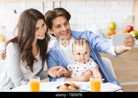 Millenaria fotografare i genitori stessi con baby figlio Foto Stock