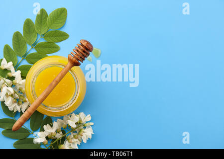 Il miele di fiori d'acacia su sfondo blu Foto Stock