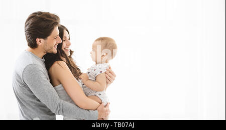 I giovani genitori godendo momenti incantevoli con il loro adorabile baby Foto Stock