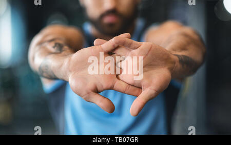 Uomo in fase di riscaldamento le sue mani prima di allenamento Foto Stock