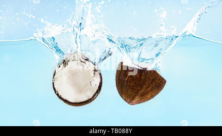 Incrinato noce di cocco con schizzi cadere in acqua Foto Stock