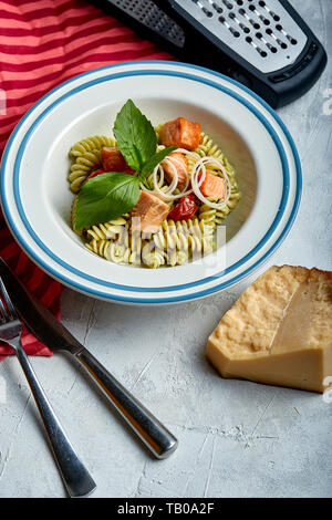 Fusilli con salmone al forno e spinaci. Il concetto di cucina italiana classica. Splendidamente conserve di tavola con la pasta. Foto Stock