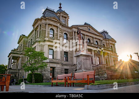 Cadice, Ohio/USA-Maggio 15, 2019: Harrison County Courthouse con una statua di John A. Bingham davanti e sunburst dal sole che tramonta dietro il buildi Foto Stock