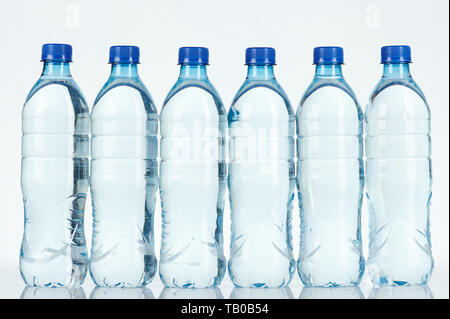 Pulire azzurro bottiglie acqua fila isolati su sfondo bianco Foto Stock