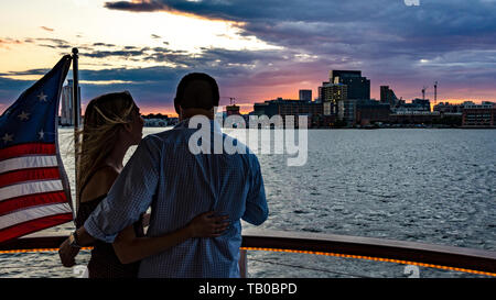 Baltimore, Maryland, Stati Uniti d'America - 8 Luglio 2017: un giovane si gode della vista del Baltimore Inner Harbor skyline su una crociera al tramonto. Foto Stock