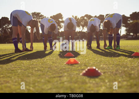 Squadra di calcio femminile giocatori facendo il warm-up esercizio sul campo Foto Stock