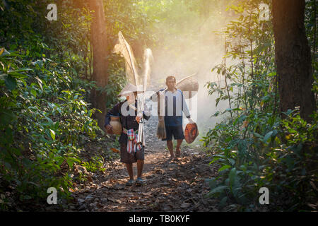 Asia fisherman tenere net e strumenti da pesca a piedi nella foresta al fiume della vita di campagna persona Foto Stock