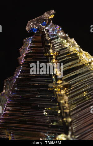 Cristallo di bismuto contro uno sfondo nero. Foto Stock