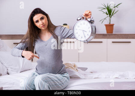 Giovane donna incinta in camera da letto Foto Stock