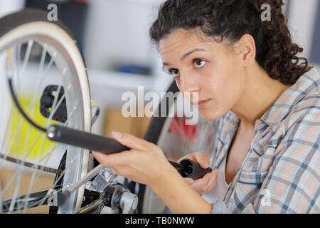 Donna di pompaggio pneumatico pneumatico con pompa per la bici Foto Stock