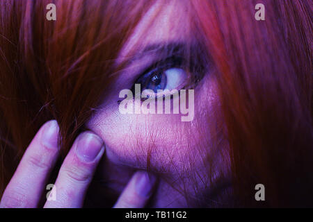 Volto di donna coperta con i capelli rossi. Blue eye. Foto Stock
