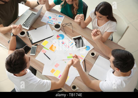 Un gruppo di persone in preghiera prima di un incontro in ufficio Foto Stock