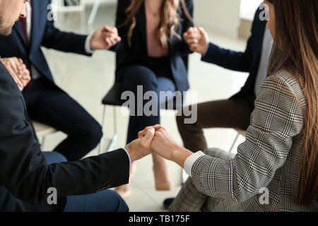 Un gruppo di persone in preghiera prima di un incontro in ufficio Foto Stock