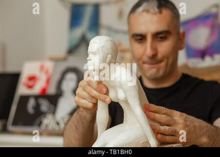 Scultore rendendo la ragazza figurina di argilla bianca Foto Stock