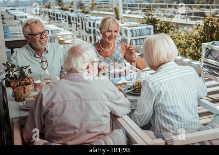 Allegro uomo barbuto parlando con i suoi amici Foto Stock