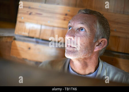 Incredibile ritratto di un anziano uomo caucasico chi è un mugnaio in un mulino a vento olandese il controllo all'interno di un tratteggio per vedere se tutto funziona correttamente Foto Stock