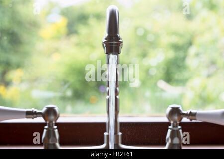 Rubinetti da cucina lasciato in esecuzione e sprechi di acqua. Regno Unito. Foto Stock