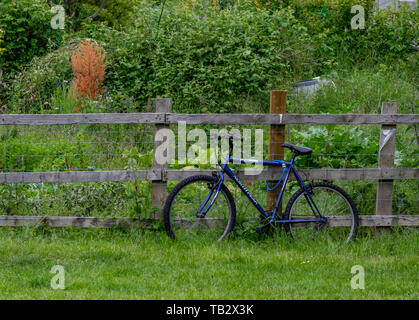 Bike legato ad un palo da recinzione Foto Stock