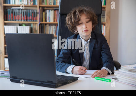 Istruzione, infanzia e scuola concetto. Ragazzo fare i suoi compiti Foto Stock