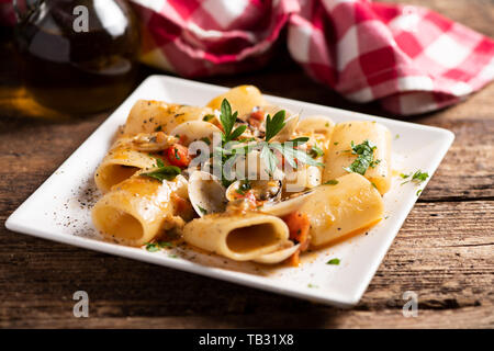 Pasta paccheri con vongole sulla piastra bianca close up Foto Stock