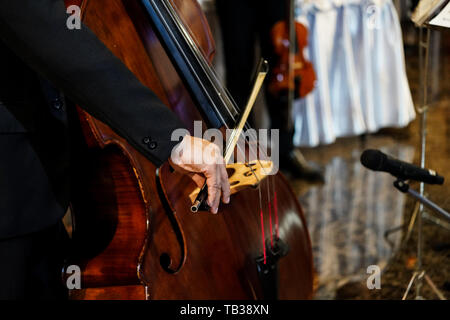 Close up del musicista è mano giocando double bass in evento indoor Foto Stock