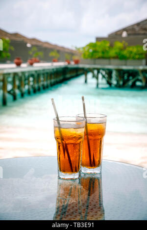 Tè freddo contro tropicale bungalow Overwater Resort, Maldive. Foto Stock