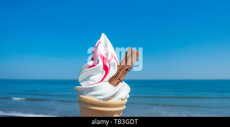 Novanta nove cono gelato con lampone contro il blu del cielo e del mare. Regno Unito Foto Stock