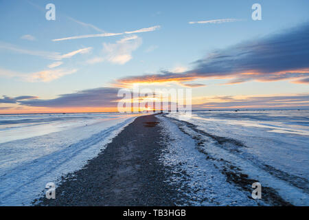 Tramonto sulla penisola lunga poco profonda nel Mar Baltico, gelido inverno. Percorso per il sun. Foto Stock