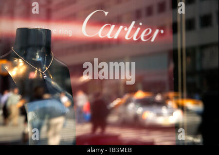 Fifth Avenue il traffico è riflessa nella finestra di Cartier Jewelers in Midtown Manhattan, New York, NY Foto Stock