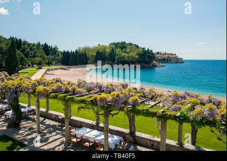 Vista dalla Villa Milocer verso Sveti Stefan, xv secolo isola villaggio costruito sulla cima di un'isola rocciosa della costa del Montenegro, e ora un lusso res Foto Stock