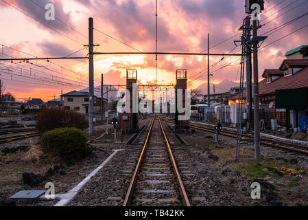 Svuotare il binario ferroviario nei pressi di una stazione ferroviaria al tramonto. Fujikawaguchiko, Giappone. Foto Stock