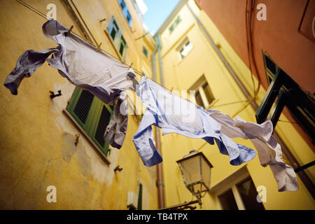 Tre magliette essiccazione su una fune a Riomaggiore, il più grande dei cinque secoli-vecchi borghi delle Cinque Terre, situato sul robusto costa nordoccidentale della Ita Foto Stock